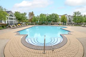 Belleville apartment for rent - A large swimming pool surrounded by a brick patio.
