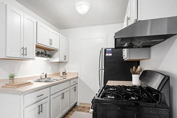 An upgraded kitchen with white cabinets and stainless steel appliances