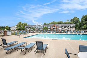 Walker apartment for rent - A pool with sun loungers and an apartment building in the background at Apple Ridge Apartments, Michigan, 49534