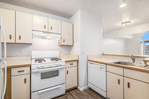 Mishawaka townhouse for rent - a kitchen with white appliances and wooden cabinets at Autumn Lakes Apartments and Townhomes, Mishawaka, 46544