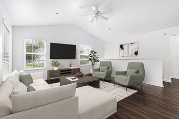 A living room with a ceiling fan, vinyl plank flooring, and two windows 