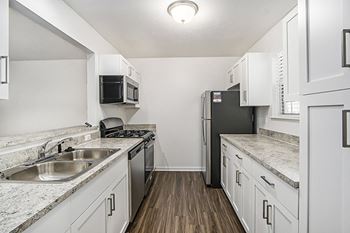 A kitchen with white, shaker-style  cabinets and stainless steel appliances