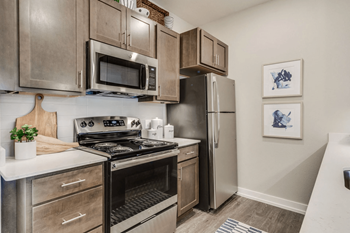 A kitchen with stainless steel appliances and wooden cabinets