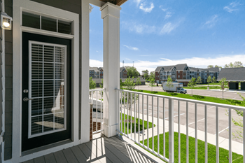 A balcony with a door and a street in the background