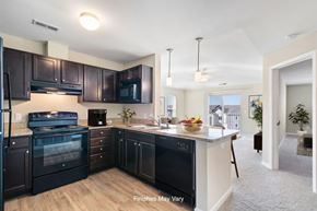 Kennewick apartment for rent - A kitchen with dark brown cabinets and black appliances.