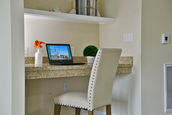 A desk with a laptop and a chair in front of it