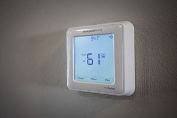 A white thermostat sitting on top of a white wall
