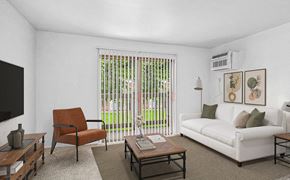 Benton Harbor apartment for rent - A living room with a white couch and a slider to a balcony at Briarwood Apartments in Benton Harbor, MI