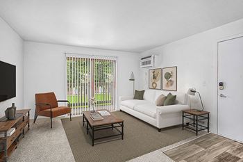 A living room with a couch, and a slider to a balcony