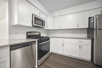 A kitchen with white cabinets and stainless steel appliances