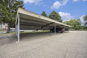 A car is parked under a large carport bay