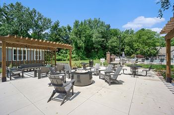 A sunny day at the fire pit with chairs as well as grills and pergolas