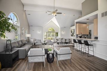 Lansing apartment for rent - A living room with a grey sofa and a grey armchair.