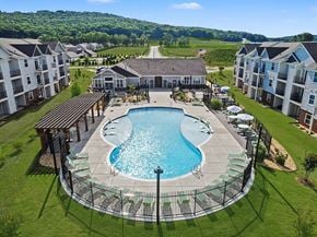 Huntsville apartment for rent - A large swimming pool with a sundeck and pergola and buildings in the background at Chase Creek Apartment Homes, Huntsville, 35811