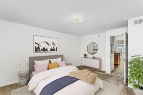 Bellevue apartment for rent - A bedroom with a bed, nightstand, and a painting on the wall at Colonial Pointe at Fairview Apartments, Bellevue, Nebraska