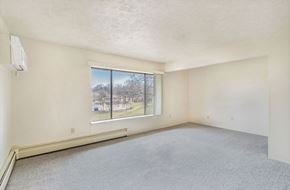 Kalamazoo apartment for rent - A living area with a large window overlooking trees at Concord Place Apartments, Kalamazoo, MI, 49009