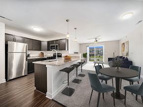 Maize apartment for rent - A kitchen with a refrigerator, a counter, and a dining table at Copper Creek Apartment Homes, Maize, Kansas