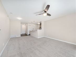 Maize apartment for rent - A spacious living room with a ceiling fan and carpeted floor at Copper Creek Apartment Homes, Maize, Kansas