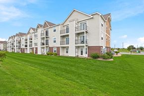 Maize apartment for rent - A row of apartment buildings with green lawns in front.