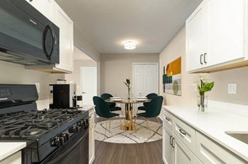 A kitchen with a stove and a table with chairs