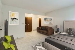 Lake Orion apartment for rent - A bedroom with a large bed, a couch, and a painting on the wall.