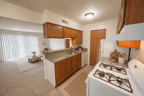 Wixom apartment for rent - A kitchen with a white stove top oven and wooden cabinets.