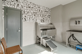A kitchen with a large silver sink and a mural on the wall