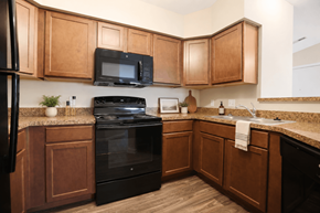Collierville apartment for rent - A kitchen with wooden cabinets and black appliances.