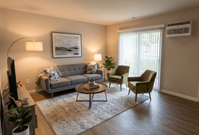 Lake Orion apartment for rent - A living room with a grey couch, two chairs, a coffee table, and a television.