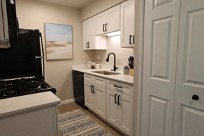 Lake Orion apartment for rent - A kitchen with white cabinets and a black stove top oven.