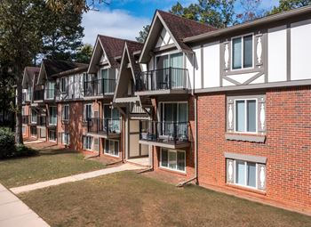 A row of red brick houses with white trim and balconies