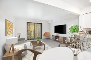 Kalamazoo apartment for rent - A living room with a white sofa, and a wooden coffee table leading to a balcony at Emerald Park Apartments, Michigan, 49001