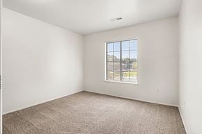 Kalamazoo apartment for rent - A bedroom with a carpeted floor and a large window at Emerald Park Apartments, Kalamazoo, Michigan
