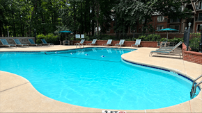 Greenville apartment for rent - A large swimming pool surrounded by trees and chairs.