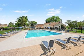 Springfield apartment for rent - Outdoor swimming pool with lounge chairs and clubhouse at Fairlane Apartments, Springfield, MI