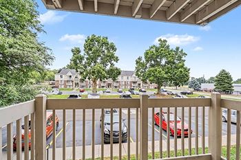 Covered balcony overlooking parking area and landscaping