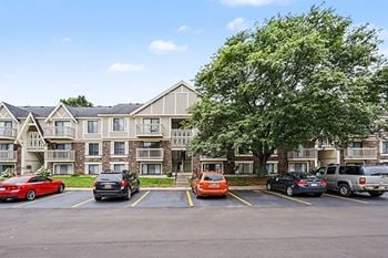 Apartment community exterior with parking and landscaping