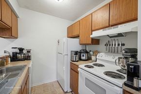 Batavia apartment for rent - A kitchen with a white stove top oven and a white refrigerator.