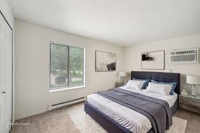 Batavia apartment for rent - A bedroom with a bed, nightstands, and pictures on the wall.