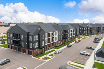 An aerial view of a row of apartment buildings in a parking lot