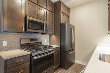 A kitchen with dark wood cabinets and stainless steel appliances