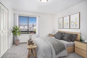 Battle Creek apartment for rent - A bedroom with a large window, bed, and a closet at Glenn Valley Apartments in Battle Creek, MI