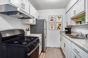 Jackson apartment for rent - An upgraded kitchen with a gas stove top and a refrigerator at Granada Apartments, Jackson, 49202