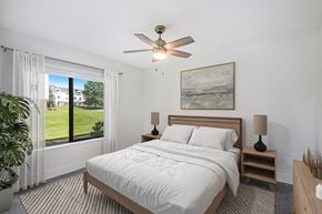 Grand Rapids apartment for rent - A bedroom with a large bed, a ceiling fan, and a window at Green Ridge Apartments, Grand Rapids, MI