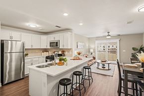 Lincoln apartment for rent - A kitchen with white cabinets and a stainless steel refrigerator at The Grove Apartment Homes, Nebraska