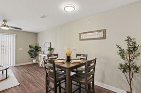 Lincoln apartment for rent - A dining room with a table set for four and a plant on the side at The Grove Apartment Homes, Nebraska
