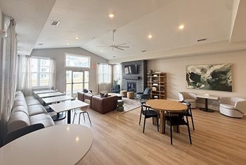 A spacious community building with hard-surface flooring and several windows 