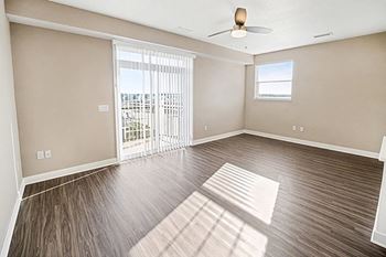 An enlarged living room with a ceiling fan and sliding glass doors