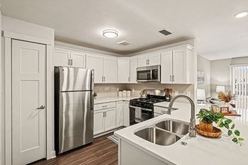 A kitchen with white cabinets and a stainless steel appliances 
