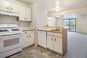 A kitchen with a white stove and dishwasher